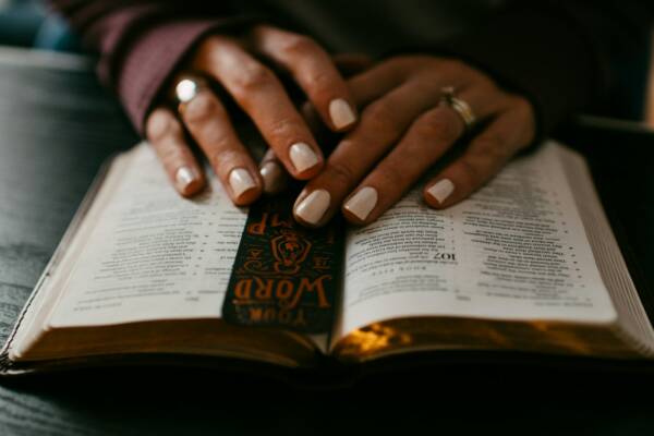 person wearing silver ring on ring finger on book page
