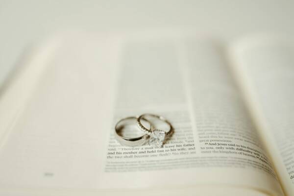 Wedding rings rest upon an open book.