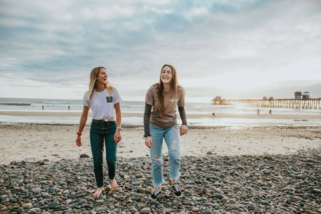 two women walking on pebbles