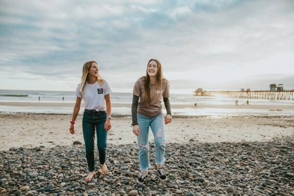 two women walking on pebbles