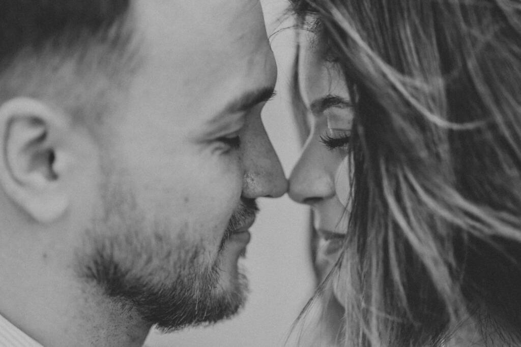 Couple touching noses in black and white.