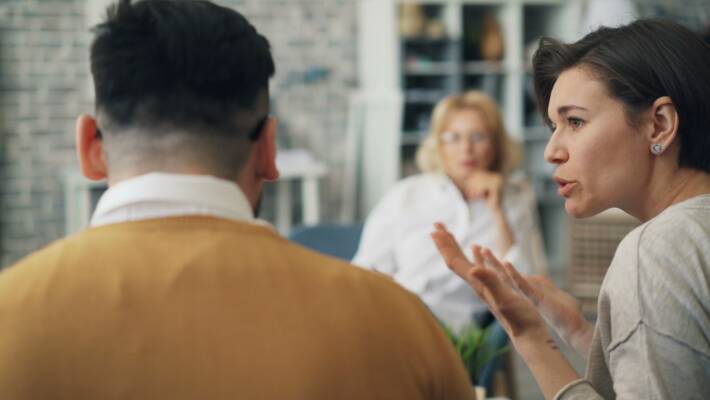 a woman talking to a man at a table