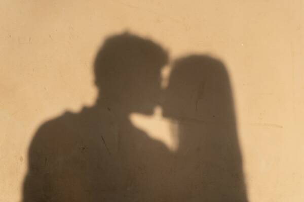 Shadows of a couple sharing a passionate kiss.
