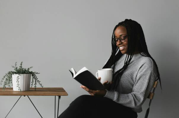 woman in white and black stripe long sleeve shirt sitting on chair
